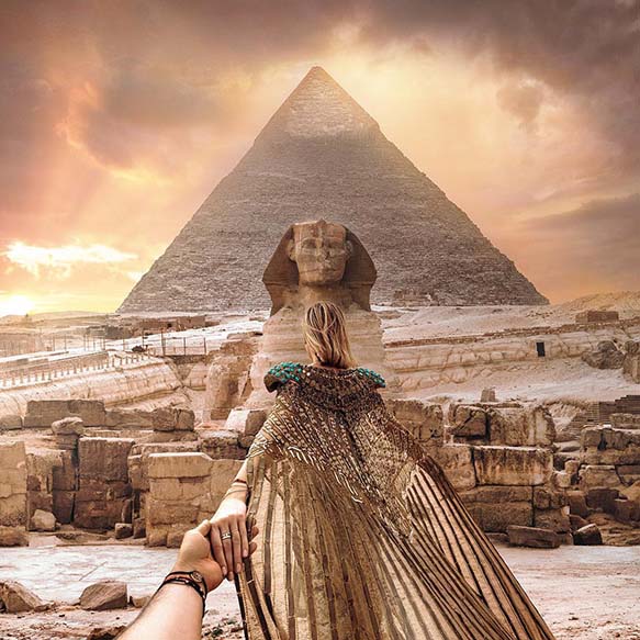 ultimate Egypt tour, a lady leading someone by hand to towards the pyramids and sphinx