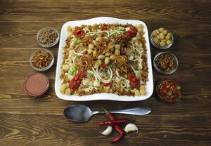 a koshary dish, a traditional Egyptian meal, contains lintel, rice, pasta, tomato sauce, onions